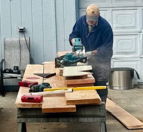 Ron Craig cutting wood using a circular saw during custom deck construction project by R.V. Craig Construction in Spokane Valley, WA